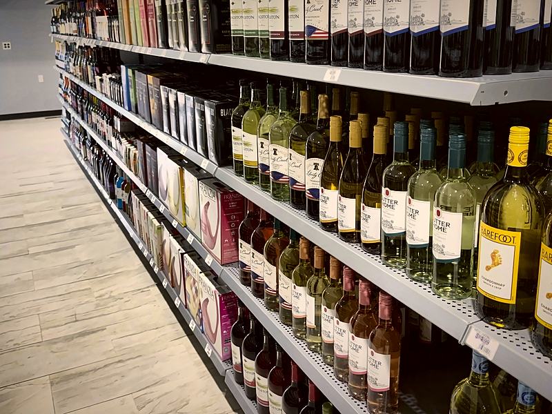 Long wine aisle with white wines on the upper shelves and reds below