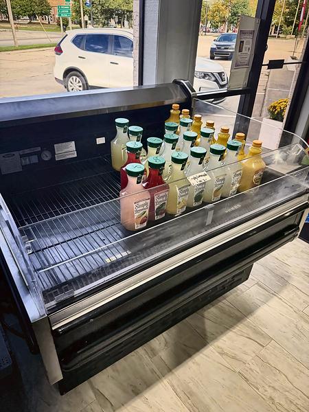 Chilled open cooler of bottled lemonades and juices by the front window