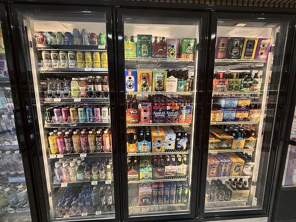 Cooler doors with cold craft beer, seltzers and bottled drinks