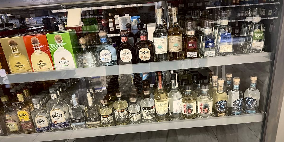 Glass counter case with Patrón gift boxes, Don Julio and 1800 tequila