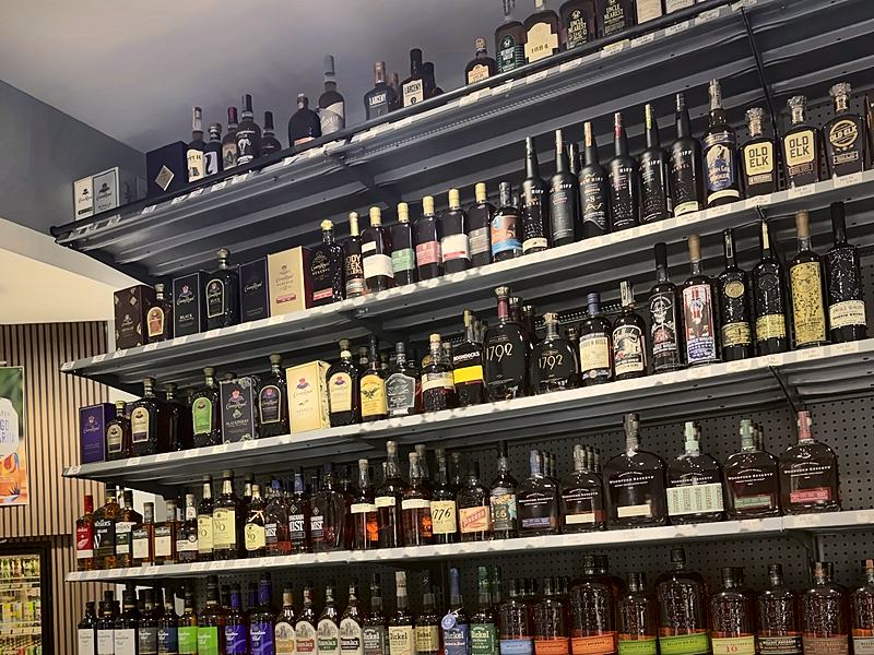 Floor-to-ceiling wall of bourbon and whiskey behind the counter